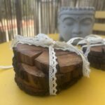 Lot de dessous de verre faits main en bois naturel. Chaque pièce présente des formes organiques uniques et conserve l'écorce d'origine. Livré avec un ruban décoratif en dentelle écrue.