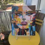 Tableau décoratif visage féminin avec regard intense et détails artistiques
