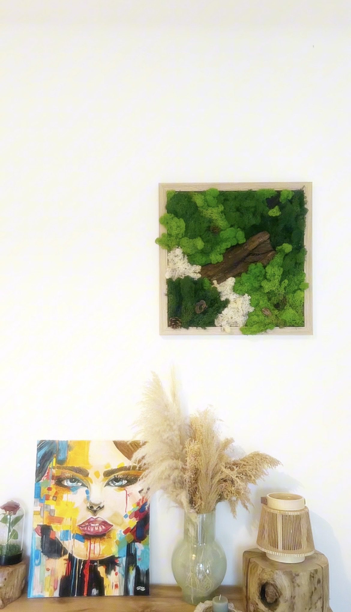 Vue d’ensemble d’un tableau végétal stabilisé accroché au mur, avec une composition harmonieuse de mousses colorées.